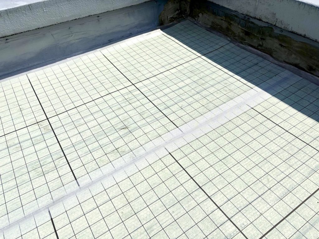 屋上に均一に貼り込まれた自着シートの写真
