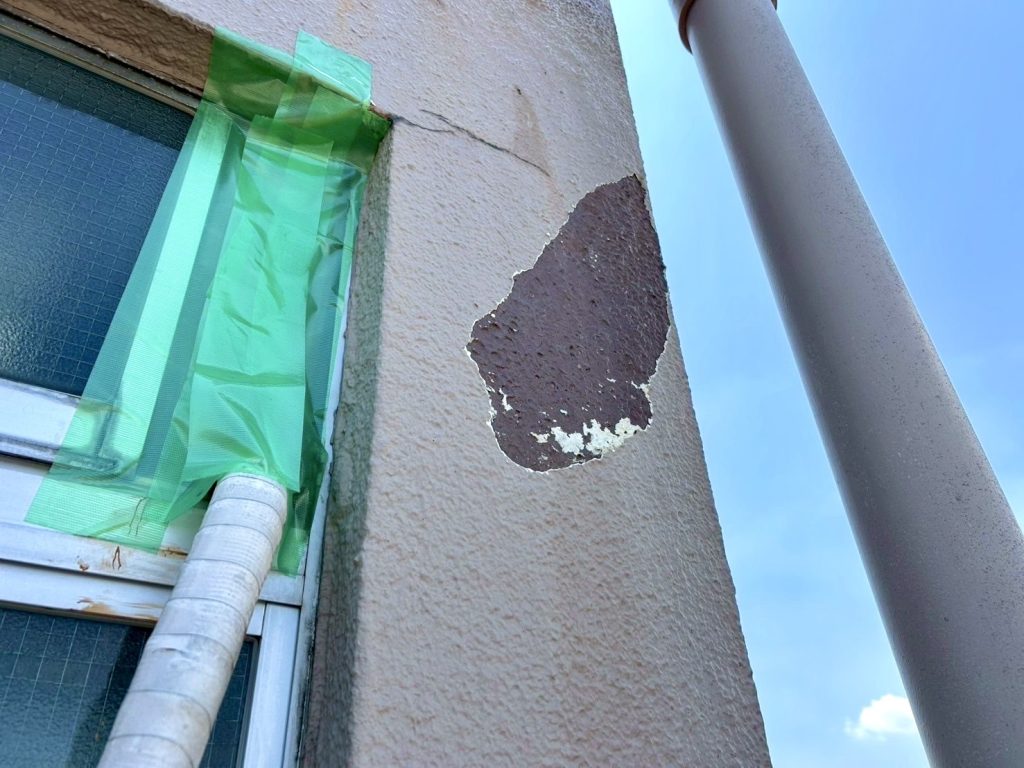 外壁の塗膜を剥がして下地が見えている様子