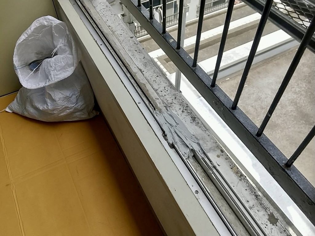 既存窓の下枠部分にシーリング材を充填し、止水処理を行っている様子。