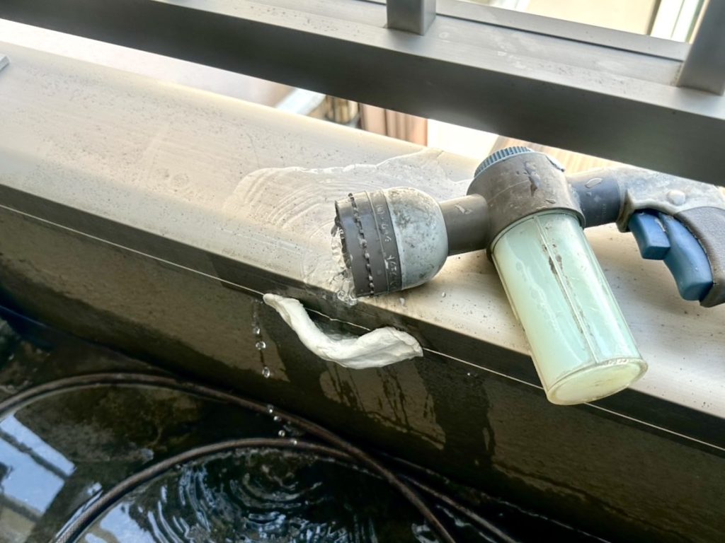 笠木下のクラック部分へ調査液（グリーン）を添加して散水